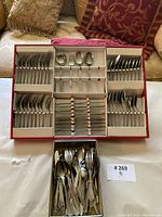 Overview of boxed stainless flatware set and loose extras