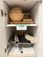 Wood bowls nested atop cutting boards in cabinet