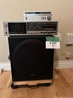 Front view of Polk Audio subwoofer with Fisher equalizer and Aiwa tuner stacked on top, lot label visible