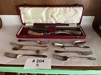 Full lot showing carving set in case, forks, spoons