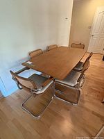 dining table with six Cesca-style chairs shown from side angle