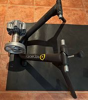 CycleOps trainer on black mat showing frame, resistance unit, and branding