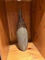 Grey wood-grain finish vase standing in shelf