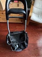 Front view of folding grocery cart showing handle, frame, bag and wheels