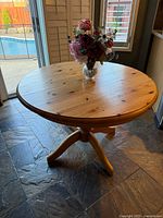 round wood pedestal kitchen table with flowers on top