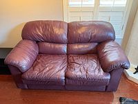 Front view of cranberry leather loveseat