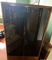 Front view of wood stereo cabinet with smoked glass doors and casters