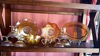Overview of four marigold carnival glass pieces on shelf