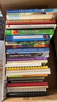 Box of stacked cookbooks giving overall quantity and variety