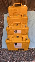 Four stacked yellow Pelican 1400 cases showing exterior and labels