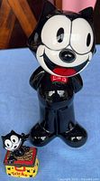 Tall Felix the Cat coin bank beside small trinket box