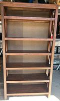 Full front view of six-shelf brown wood bookcase