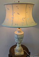 Full view of alabaster lamp with illuminated embroidered shade