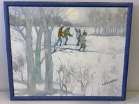 Full view of framed winter skiing scene, signature visible