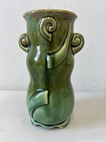 Front view showing drip-glaze coloration, scroll handles, curved band