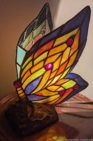 Front view of stained glass butterfly lamp lit