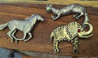 Front view of horse, cat and elephant brooches