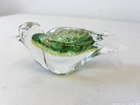 Left side view of clear glass bird showing green and yellow inclusions