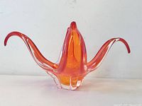 Front view of red/orange Chalet art glass bowl showing four flared wings and clear base