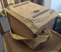 Angle view showing side, lid, strap, brass hardware