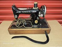 Sewing machine on wood base with motor, lamp, cord, knee lever