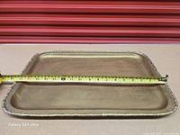 Top view of brass tray with measuring tape showing width