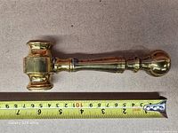 Gavel beside tape measure showing length