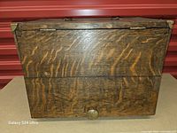 Front view of closed tiger oak box showing wood grain and brass pull