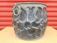 Front view showing textured brass cauldron and ring handle