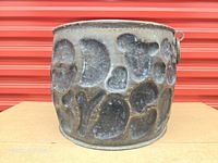 Front view of brass cauldron showing textured pattern and patina