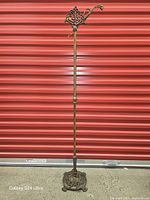 Full view of antique bridge floor lamp stand against red backdrop