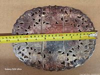 Top view collapsed trivet with tape measure showing ~19 cm width