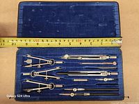 Open case with drafting instruments, measuring tape shows length