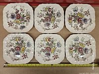 Six Johnson Bros Sheraton square plates, top view with tape measure