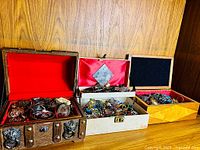 Overview of three jewelry boxes filled with assorted costume jewelry