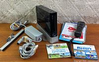 Complete Wii set laid out with console, cables, controller, manuals, and two games