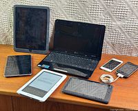 Group shot of all seven devices on wooden surface