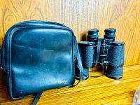 Binoculars beside Tasco zip case