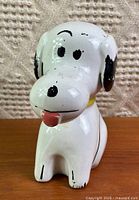 Front view of ceramic Snoopy bank showing facial details and glaze