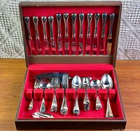 Open chest showing full assortment of flatware pieces in red felt interior