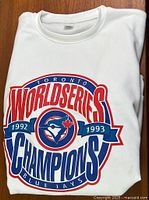 Folded white sweatshirt showing full front graphic