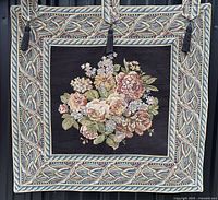Full view of tapestry showing floral panel, border, hanging loops and tassels