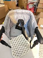 Overall view of baby seat unfolded showing harness and clamps