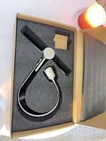 Faucet pieces in foam packaging showing black body and silver accents