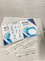 Three boxed Lemas acrylic sign holders with separate acrylic bases visible