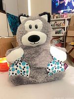Front view of grey husky/wolf plush pillow showing overall design, face, and polka-dot paws
