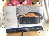 Front view of retail box showing Mainstays roaster oven with cooked turkey