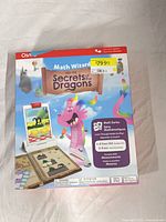 Front of sealed Osmo Math Wizard Secrets of the Dragons box showing artwork, price sticker, age range and product details