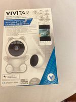 Front of sealed retail box showing Vivitar Wi-Fi Baby Cam, branding, 1080p spec, Google Assistant and Amazon Alexa compatibility
