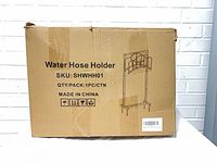 Front of carton showing product name, SKU SHWHH01, quantity 1, made in China, with line drawing of stand